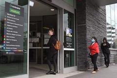 Người dân xếp hàng bên ngoài trung tâm trợ cấp ở Melbourne. (Ảnh: AFP/ TTXVN)