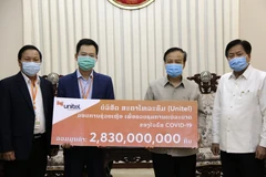 Đại diện Star Telecom trao tượng trưng số tiền ủng hộ tương đương 320.000 USD cho Chính phủ Lào. (Ảnh: Phạm Kiên/TTXVN) 