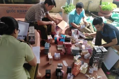 Lực lượng quản lý thị trường kiểm tra lô hàng bị thu giữ. (Ảnh: TTXVN phát) 