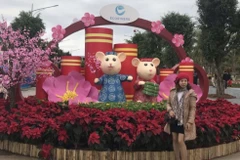 Người dân chụp ảnh bên biểu tượng chú chuột tại lễ hội hoa xuân. (Ảnh: Tiến Vĩnh/TTXVN) 