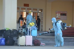 Khử trùng hành lý của công dân từ Hàn Quốc trở về. (Ảnh: Văn Dũng/TTXVN)