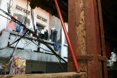 Cột nhà gỗ đã bị mối mọt xông nên phải gia cố thêm. (Ảnh: Ngọc Hà/TTXVN)