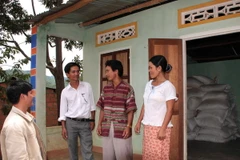 Cán bộ xã tuyên truyền, vận động người dân tích trữ lương thực nhằm phòng chống thiếu lương thực khi bị mưa lũ. (Ảnh: Trần Lê Lâm/TTXVN)