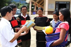 Cán bộ Sở Tư Pháp hướng dẫn người dân xã Cư Pui, huyện Krông Bông, Đắk Lắk tìm hiểu các văn bản pháp lý. (Ảnh: Phạm Cường/TTXVN)