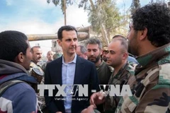 Tổng thống Syria Bashar al-Assad (giữa) thăm các binh sĩ Chính phủ tại mặt trận Đông Ghouta ngày 18/3. (Nguồn: THX/ TTXVN)