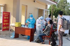 Lực lượng chức năng đưa các trường hợp trở về từ quận Gò Vấp, thành phố Hồ Chí Minh vào cách ly tập trung xã Suối Rao, huyện Châu Đức và thực hiện lấy mấu xét nghiệm. (Ảnh: Hoàng Nhị/TTXVN)