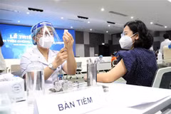 Các y, bác sỹ chuẩn bị thuốc tiêm chủng vaccine phòng COVID-19 cho người lao động. (Ảnh: Thanh Vũ/TTXVN)