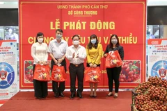 Chủ tịch UBND thành phố Cần Thơ Trần Việt Trường trao các túi vải thiều cho những tổ chức, cá nhân đặt mua đầu tiên tại lễ phát động. (Ảnh: Thanh Liêm/TTXVN)