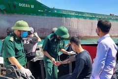 Tiếp nhận ba ngư dân trên tàu cá bị chìm. (Ảnh: TTXVN phát)