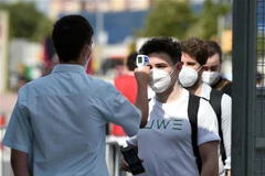 Kiểm tra thân nhiệt trước khi vào dự một sự kiện ở Tây Ban Nha. (Ảnh: AFP/TTXVN)