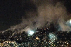 Lực lượng Phòng cháy chữa cháy tiếp tục phun xịt tại những khu vực có nguy cơ cháy trở lại. (Ảnh: Quốc Dũng/TTXVN)