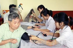 Các y, bác sĩ trẻ đang khám bệnh cho thương, bệnh binh. (Ảnh: Đình Trân/TTXVN)