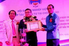 Đại diện Ngân hàng Sacombank Chi nhánh Lào nhận bằng khen. (Ảnh: Hoàng Chương/Vietnam+) 