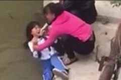 Hình ảnh bà mẹ dọa ném con xuống sông. (Nguồn: Daily Mail)