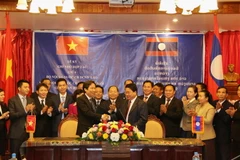 Thứ trưởng Trần Anh Tuấn bắt tay Thứ trưởng Bộ Nội vụ Lào Khammoune Viphongsay. (Ảnh: Phạm Kiên/Vietnam+)