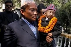 Khagendra Thapa Magar, được bố bế đi gặp gỡ giới báo chí trước lúc rời Nepal đến châu Âu. (Ảnh: AP)
