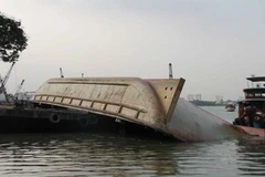 Hiện trường chiếc xà lan chở cát lật úp trên sông Sài Gòn. (Ảnh: Thế Vinh/TTXVN) 