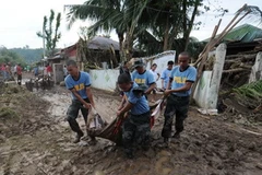Nhân viên cứu hộ chuyển xác nạn nhân bão Washi ở Cagayan de Oro trên đảo Mindanao, ngày 18/12. (Nguồn: AFP/TTXVN)