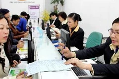 Nhân viên nhà mạng hướng dẫn khách hàng đăng ký hòa mạng di động. (Ảnh: Minh Tú/TTXVN)