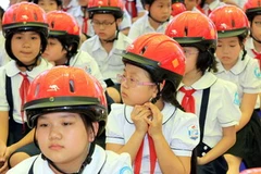 Trao mũ bảo hiểm cho học sinh tiểu học. (Ảnh minh họa: Thanh Tùng/TTXVN)