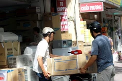 Người mua máy điều hòa ở một cửa hàng đồ điện. (Ảnh: Bùi Tường/TTXVN)