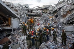 Cứu người bị thương từ đống đổ nát của một tòa nhà ở thủ đô Port-au-Prince, Haiti ngày 16/1. (Ảnh: THX/TTXVN) 