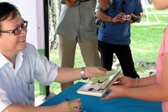 Nhà văn Nguyễn Nhật Ánh ký tặng độc giả. (Nguồn: thanhnien)