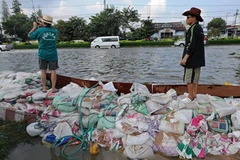 Người dân dùng bao cát chắn nước lụt ở thủ đô Bangkok ngày 23/10. (Nguồn: AFP/TTXVN)