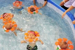 Các em bé Trung Quốc tham dự Cuộc thi bơi dành cho em bé tại Bắc Kinh ngày 11/9. (Nguồn: AFP/TTXVN) 