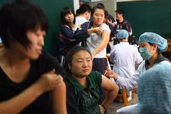 Các nhân viên y tế Trung Quốc đang tiêm vắcxin cúm A/H1N1 cho các sinh viên ở tỉnh Quảng Tây ngày 9/11. (Ảnh: Daylife)