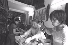 Bà Nguyễn Thị Thái, 85 tuổi, chủ một cửa hàng đông dược ở phố Lãn Ông, vừa bốc thuốc vừa dạy nghề cho hai cháu. (Ảnh: laodong.com.vn)