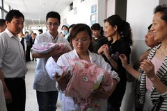 Hai cháu bé được các hộ lý đưa về phòng hậu sản. (Nguồn: Chinadaily) 