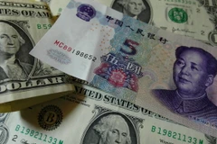 Đồng USD (trái) và nhân dân tệ (phải). (Nguồn: AFP/TTXVN)