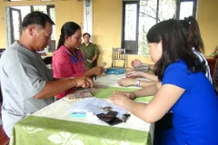 Người dân xã Lộc Điền nhận tiền bồi thường. (Ảnh: Tường Vi/TTXVN)
