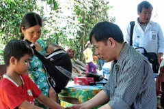 Bác sỹ Bệnh viện Bạch Mai khám cho người dân mắc hội chứng viêm da dày sừng lòng bàn tay, bàn chân tại huyện Ba Tơ, tháng 6/2012. (Ảnh: Thanh Long/TTXVN)