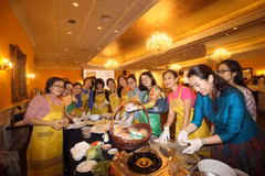 Phu nhân các cơ quan đại diện các nước ASEAN tại Malaysia thử làm món nem rán truyền thống của Việt Nam. (Ảnh: Nguyễn Hà Ngọc/TTXVN)