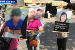 Nhiều người bị hại căng băngrôn cùng với ảnh yêu cầu Phạm Ngô Cẩm Vân trả lại số tiền đặt cọc và tiền công. (Ảnh: Nam Thái/TTXVN)