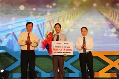 Đồng chí Nguyễn Đức Lợi, Ủy viên Trung ương Đảng, Tổng Giám đốc Thông tấn xã Việt Nam trao tặng 1,8 tỷ đồng xây dựng 3 phòng học cho trường mầm non xã Triệu Tài, huyện Triệu Phong, tỉnh Quảng Trị. (Ảnh: Nguyên Lý/TTXVN)