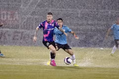 Sài Gòn FC (áo tím) và Hồng Lĩnh Hà Tĩnh 'thủy chiến' trên sân Thống Nhất. (Ảnh: Thanh Vũ/TTXVN)