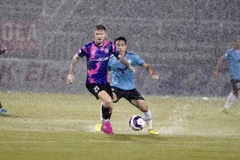 Sài Gòn FC (áo tím) và Hồng Lĩnh Hà Tĩnh 'thủy chiến' trên sân Thống Nhất. (Ảnh: Thanh Vũ/TTXVN)