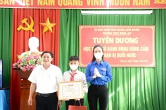 Tỉnh đoàn Hà Tĩnh trao tặng Bằng khen cho em Nguyễn Văn Dương vì đã có hành động dũng cảm cứu bạn nhỏ khỏi đuối nước. (Ảnh: Hoàng Ngà/TTXVN)