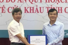 Đại diện của Vụ Quy hoạch kiến trúc, Bộ Xây dựng trao Hồ sơ quy hoạch chung xây dựng Khu kinh tế cửa khẩu tỉnh Cao Bằng cho đại diện lãnh đạo tỉnh Cao Bằng. (Ảnh: Quốc Đạt/TTXVN)