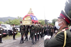 Đội tiêu binh di cốt các liệt sỹ ra xe để hồi hương về đất mẹ. (Ảnh: Phạm Kiên/TTXVN)