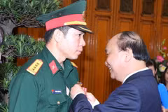 Thủ tướng Nguyễn Xuân Phúc trao tặng Huân chương lao động hạng Nhất cho vận động viên Hoàng Xuân Vinh. (Ảnh: Thống Nhất/TTXVN)
