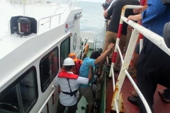 Cơ quan chức năng tiếp nhận thuyền viên tàu Thành Đạt 01 từ tàu Guo Shun 21. (Ảnh: Đoàn Mạnh Dương/TTXVN)