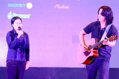 Lê Minh Sơn đệm đàn cho chị Đinh Thị Bông ở Na Rì, Bắc Cạn- nhân vật trong số đầu tiên 'Du ca Việt' trong buổi họp báo ra mắt chương trình tại Hà Nội. (Ảnh: Hải Bá)