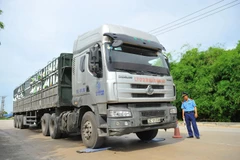 Thanh tra giao thông tỉnh Ninh Bình kiểm tra trọng tải xe tải chở hàng tại cảng. (Ảnh: Minh Đức/TTXVN)