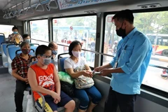 Hành khách và nhân viên xe buýt đều đeo khẩu trang. (Ảnh: Danh Lam/TTXVN)