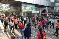 Công nhân Công ty TNHH PouYuen Việt Nam trong ngày làm việc cuối cùng trước khi tạm dừng hoạt động sản xuất. (Ảnh: Thanh Vũ/TTXVN)