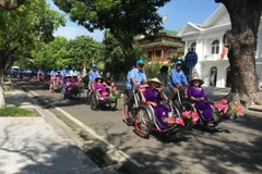 Khách du lịch tham quan cố đô Huế bằng xe xích lô. (Ảnh: Hồ Cầu/TTXVN)